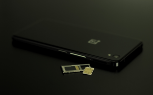 A smartphone resting next to a memory card, suggesting the storage or transfer of data between mobile devices and external media.