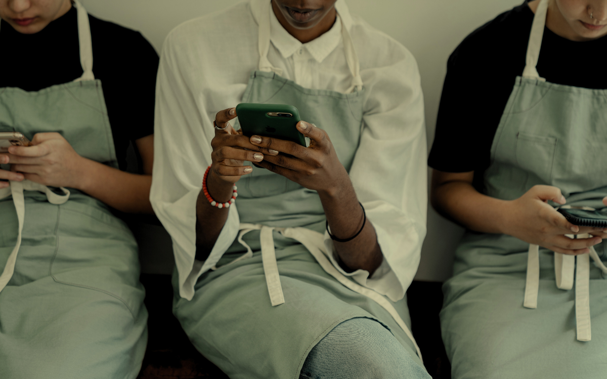 Hands holding a mobile device in a clinical setting, suggesting the integration of technology in healthcare or medical environments.