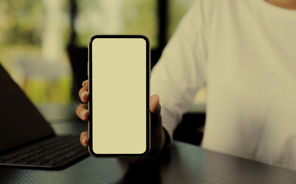 A person holding a smartphone with a blank screen, suggesting the use of mobile devices for various purposes.